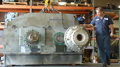Male Motion Repair & Services technician re-assembling an industrial gearbox repair at repair facility