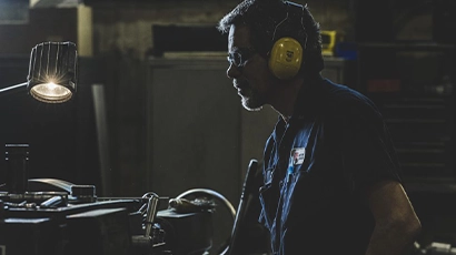 Technician running various tests to newly refurbished gearbox, including load testing, vibration analysis, and noise measurement