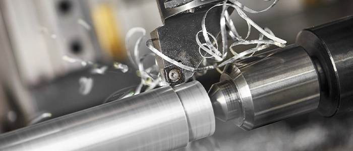 Close-up image cutting steel metal shaft processing on lathe machine in facility